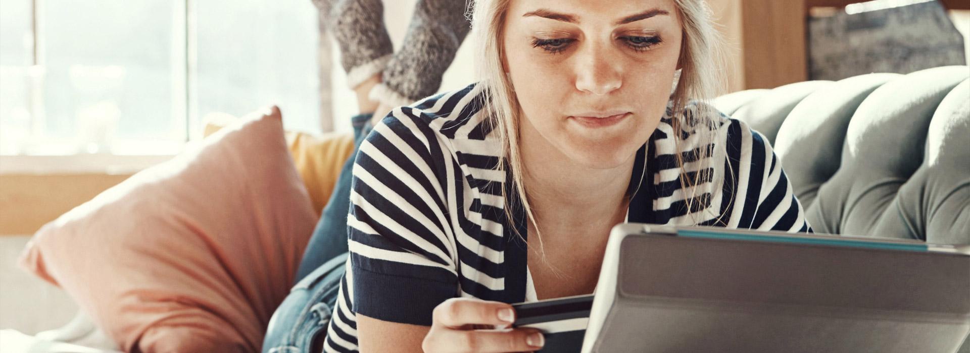 lady relaxing on couch looking at laptop