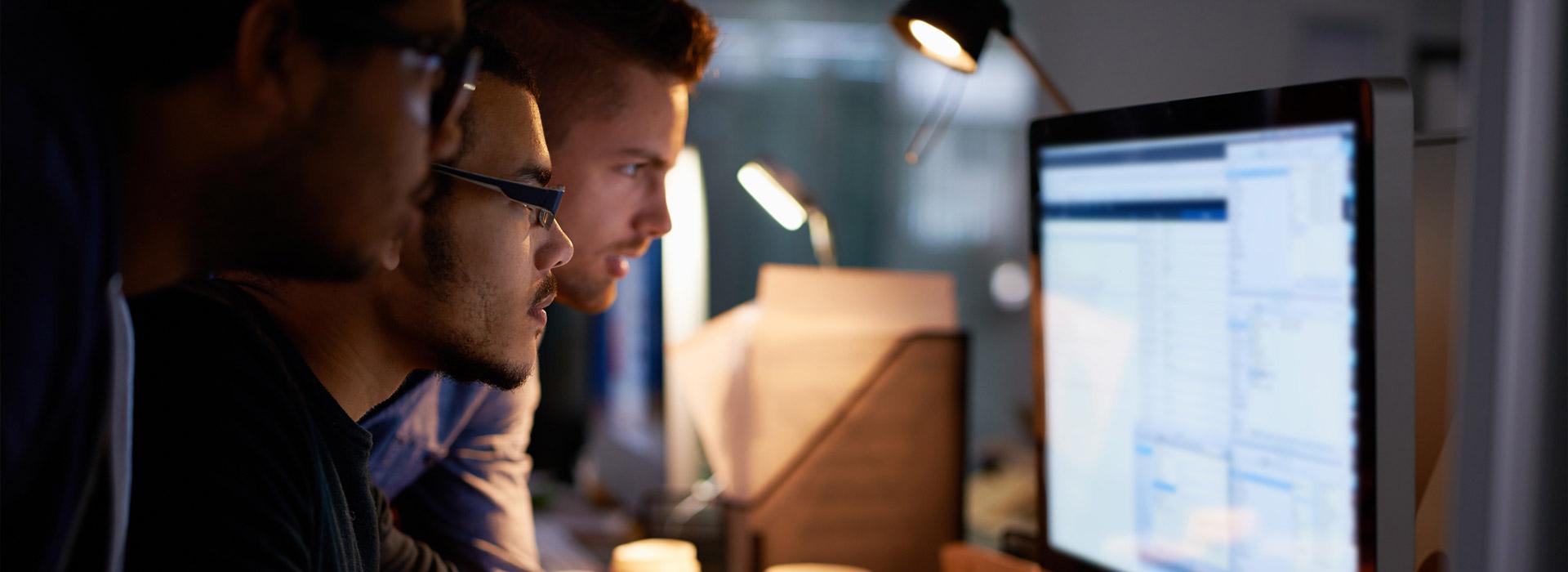 three guys looking at a computer