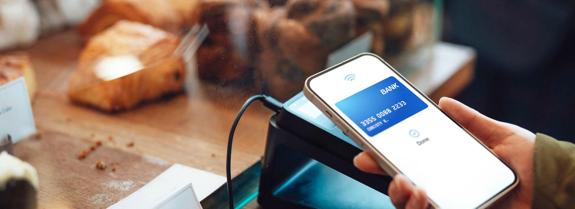 hand holding cell phone doing tap to pay